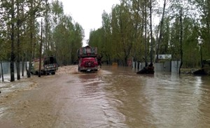 Continuous downpour inundates Srinagar-Baramulla Highway near Hanjiweera area of Pattan affecting traffic movement on Monday. —Excelsior/Aabid Nabi