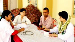 A doctor alongwith her associates examining a patient during a free medical camp organized by SRMWC at Jammu.