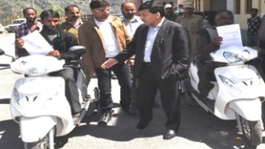 District Development Commissioner Ramban, Farooq Shah Bukhari distributing scooties to handicapped beneficiaries on Thursday.