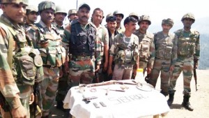 Troops pose with arms and ammunition recovered in Reasi district on Wednesday.