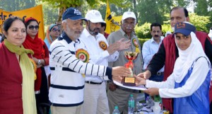 Minister for Education Naeem Akhtar felicitating a winner of cross country organised by SP Hr Sec School in Srinagar.