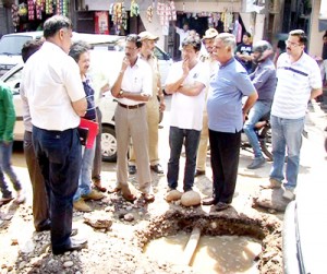 PHE Minister Sukhnandan Kumar inspecting leaked water pipes in Old Jammu city on Saturday.