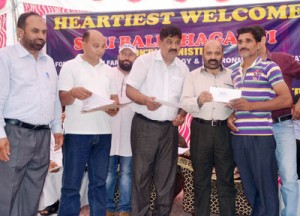 Minister for Social Welfare Bali Bhagat distributing cheque to a beneficiary on Sunday.