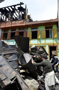 People collecting house-hold items from gutted houses. —Excelsior/Aabid Nabi