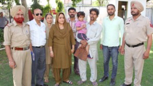 Girl child alongwith her relatives and officials posing for group photograph.