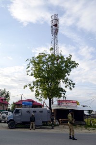 A cop stands guard to mobile tower in Baramulla on Wednesday.      —Excelsior/Aabid Nabi