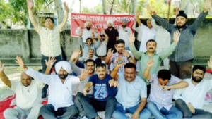 Contractors of Estates Division sitting on protest dharna at Jammu on Friday.