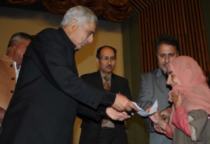 Chief Minister Mufti Mohammad Sayeed presenting cheque to a flood-hit victim at SKICC onTuesday.  —Excelsior/Amin War