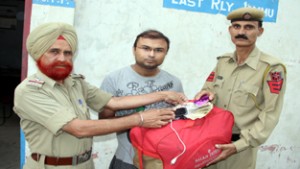 GRP men handing over the lost bag to its owner.