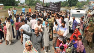 Labourers blocking NH at Pampore. —Excelsior/Younis Khaliq