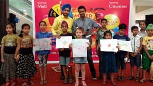 Children showing the pictures drawn by them during Wave Summer Carnival at Wave Mall, Jammu.