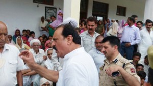 Former Minister and NC leader S S Slathia talking to flood-hit villagers at Keso Govt School in Ramgarh on Monday.