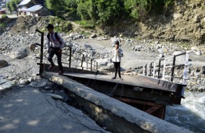 Students cross a damaged bridge in Boniyar area of north Kashmir. —Excelsior/Aabid Nabi