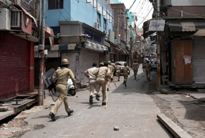 Cops chasing stone pelters at Purani Mandi in Jammu City on Sunday. -Excelsior/Rakesh