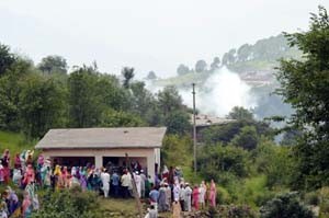 People rush towards a concrete place to take shelter as mortar shell explodes at Balakote on Sunday.