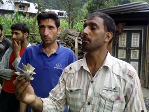 A youth shows mortar shell which landed in his house at Sabzian in Poonch sector on Sunday. -Excelsior/ Harbhajan