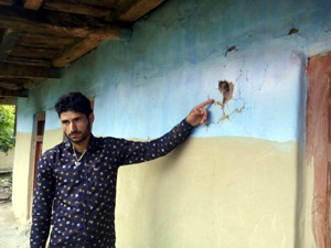 A youth shows bullet marks on his house at Sabzian in Poonch district on Friday. — Excelsior/Harbhajan