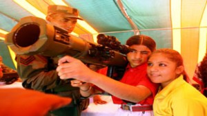 School children trying their hand on weapons displayed during a programme to commemorate 1965 war victory over Pak.