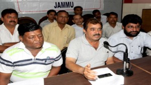 Estates employees’ leader Yash Paul Sharma, flanked by PS Bawa and Tilak Raj addressing press conference in Jammu on Friday. -Excelsior/ Rakesh