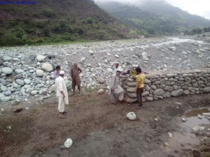 People of Kulani village in tehsil Mandi of Poonch District raising a crate to prevent the village from floods. 