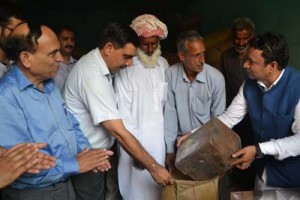 Minister for CAPD, Chowdhary Zulfkar Ali distributing ration to a villager at Rajouri on Wednesday.