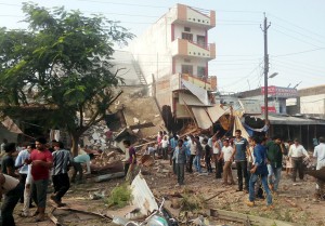 Local people milling around the site of a massive explosion at Petlavad in Jhabua district of Madhya Pradesh on Saturday. (UNI)