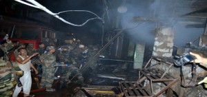 Army joins Firemen to fight devastating fire at main market in Surankote on Monday night.