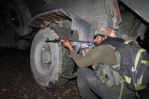 An Army soldier takes position during encounter with militants at Drabgam in Pulwama on Monday. —Excelsior/Younis Khaliq