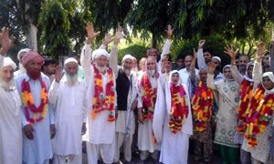 Haj pilgrims from Reasi raising slogans against State Govt. on their arrival on Friday.