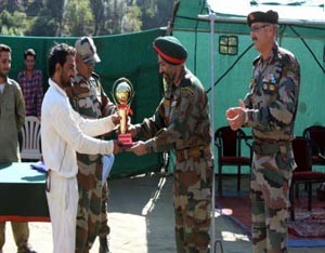 Winners trophy of a cricket tournament organized by Army being presented to skipper of Bagga A team.