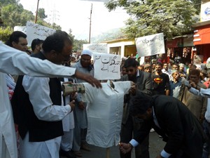 Protesters torching effigy of Forest Minister Bali Bhagat during demonstration at Ramban on Wednesday. -Excelsior/Pervez