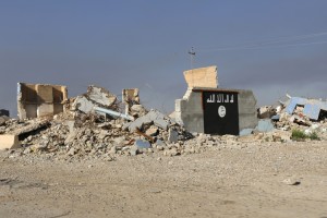 A destroyed building with a wall painted with the black flag commonly used by Islamic State militants, is seen in the town of al-Alam March 10, 2015. Iraqi troops and militias drove Islamic State insurgents out of al-Alam on Tuesday, clearing a final hurdle before a planned assault on Saddam Hussein's home city of Tikrit in their biggest offensive yet against the ultra-radical group. REUTERS/Thaier Al-Sudani (IRAQ - Tags: POLITICS CIVIL UNREST CONFLICT) - RTR4SUBK