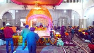 Sikh devotees paying obeisance on the 547th birth anniversary of the founder of Sikhism in Srinagar on Wednesday.                                                                     -Excelsior/Amin War