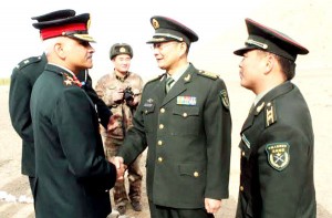 Indian Army and PLA officials shake hands during a meeting in Ladakh sector. Another pic on page 6.