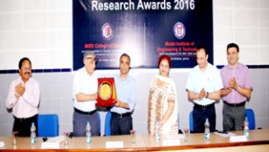 Chairman MIER presenting memento to Prof. Jigar Mohammed, Dean Research, JU during Research Awards programme on Saturday.