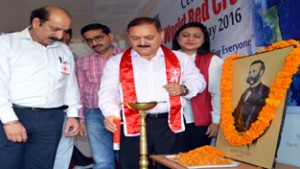 Divisional Commissioner Pawan Kotwal lighting lamp to pay tributes to Sir Henry Dunant during celebrations of World Red Cross Day at Jammu.