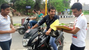 Officials of NILM educating a motorcyclist about traffic rules at Jammu. 