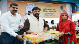 Minister for Forest Ch Lal Singh giving away gas connection to a woman on Friday.