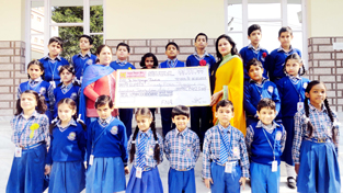 Students of Sprawling Buds School Bantalab handing over cheque to Helpage India on Tuesday.