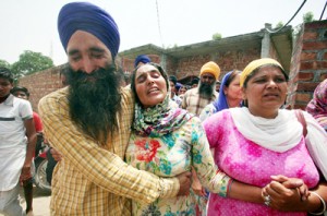 Relative console the wife of martyr Paramjeet Singh, who was killed in Poonch on Monday, at her house at Taran Taran in Amritsar on Tuesday.