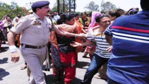 A police officer dragging a agitating health employee at Kathua.