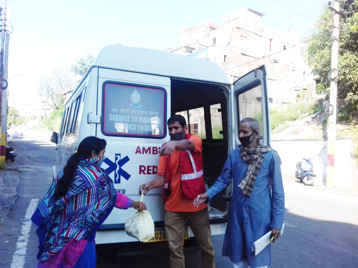 Indian Red Cross Society members providing ration to a needy in Jammu.