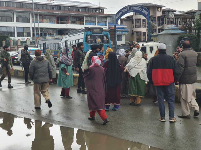 People gather at the site of militant attack in Sopore on Monday.